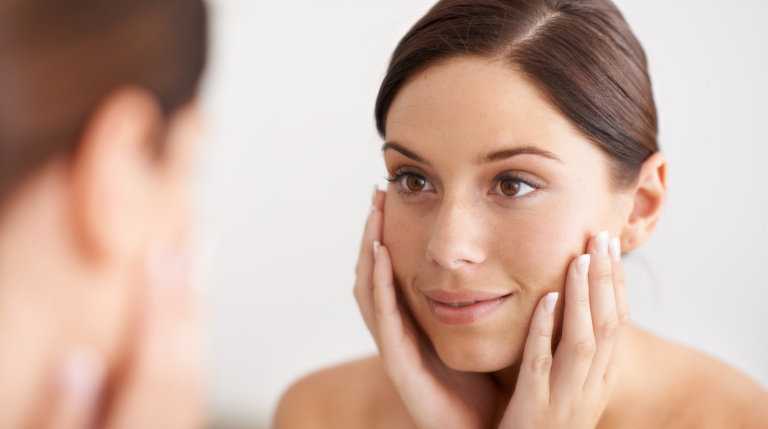 Woman smiling into the mirror after anti-wrinkle treatment