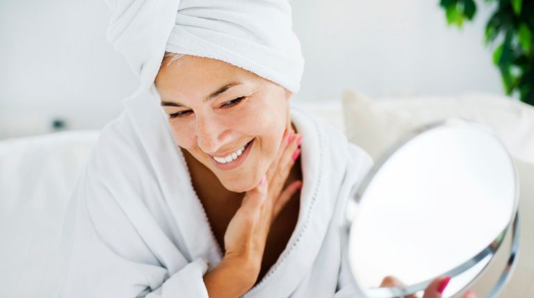 woman smiling into the mirror after an 8-Point Lift